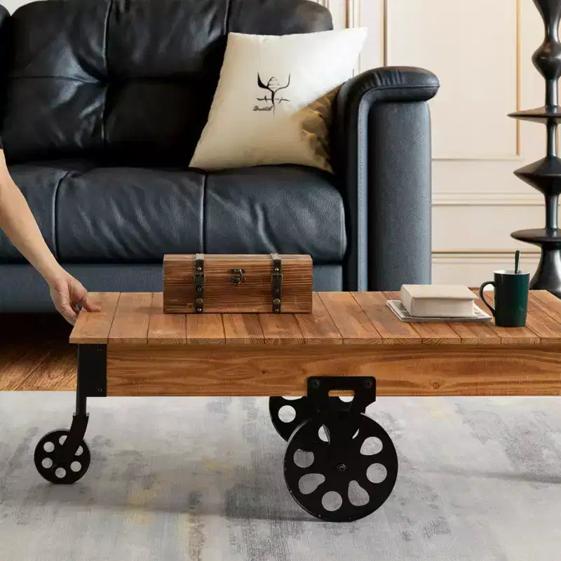 Table basse industrielle rustique Vintiquewise en bois, de grande taille, avec grain de bois détaillé, accents métalliques et roues de chariot en fonte noire